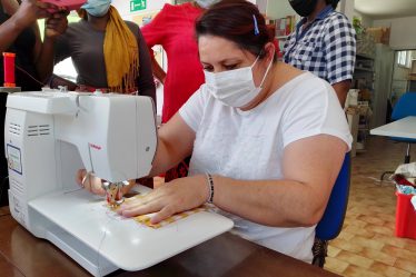 Le partecipanti al corso "intrecci di donne con le gonne" che imparano ad usare la macchina da cucire