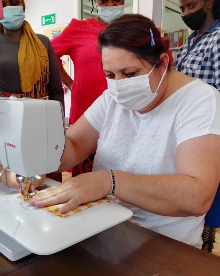 Le partecipanti al corso "intrecci di donne con le gonne" che imparano ad usare la macchina da cucire